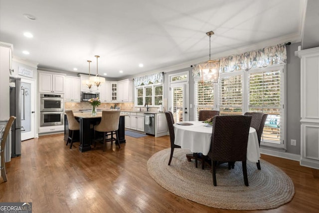 dining space featuring dark wood-style floors, recessed lighting, crown molding, and baseboards