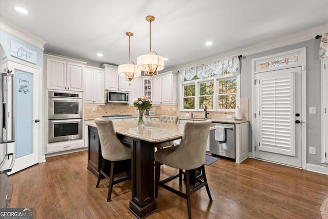 dining space featuring recessed lighting, a notable chandelier, dark wood finished floors, and ornamental molding