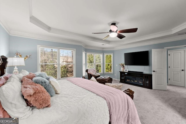 bedroom with ceiling fan, a tray ceiling, ornamental molding, and carpet flooring