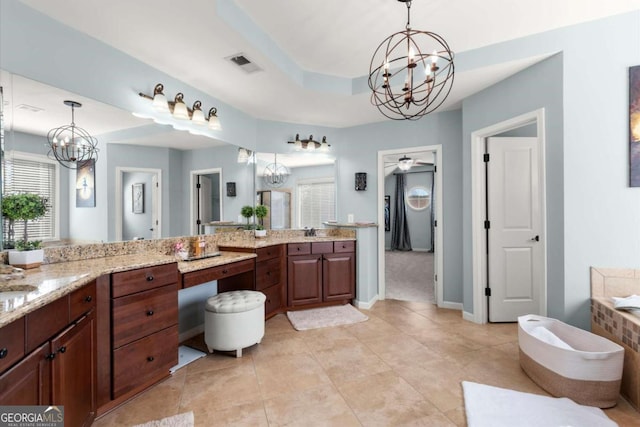 full bath featuring visible vents, ceiling fan with notable chandelier, a bath, tile patterned floors, and a raised ceiling