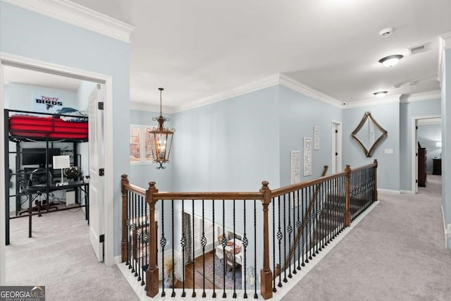 hall featuring an upstairs landing, visible vents, carpet, and ornamental molding