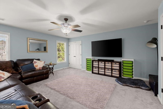 living area featuring visible vents, baseboards, a ceiling fan, and carpet floors