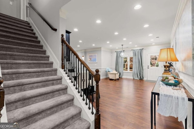 staircase with recessed lighting, crown molding, baseboards, and wood finished floors