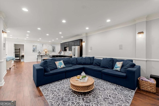 living area with recessed lighting, wood finished floors, and ornamental molding