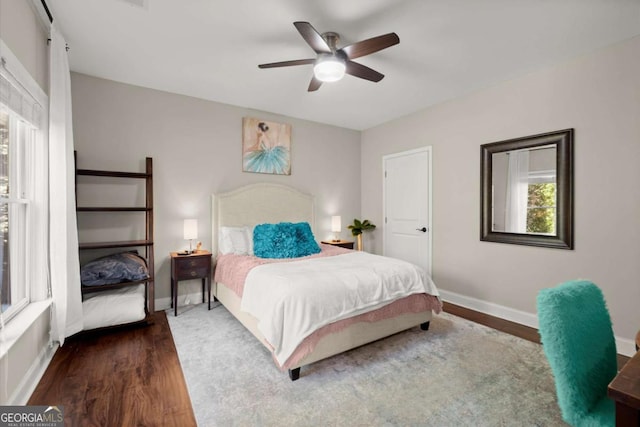 bedroom with ceiling fan, baseboards, and wood finished floors