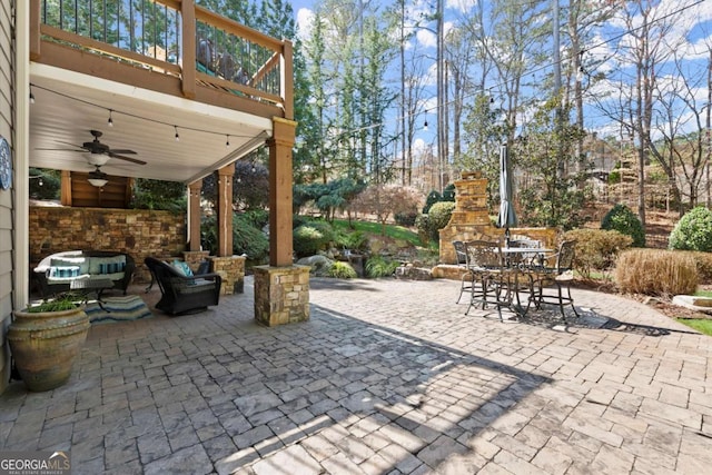 view of patio / terrace featuring outdoor dining area, ceiling fan, and an outdoor living space with a fireplace