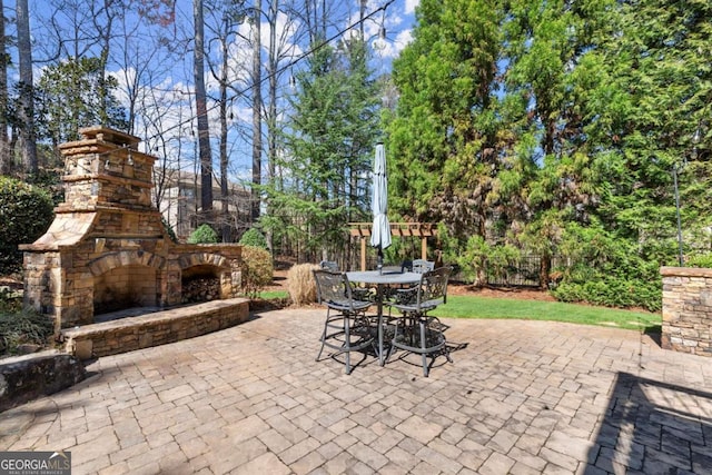 view of patio with outdoor dining area and an outdoor stone fireplace