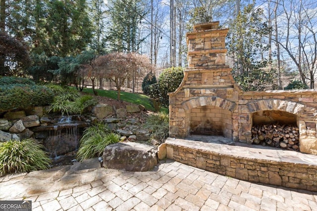 view of patio with an outdoor stone fireplace