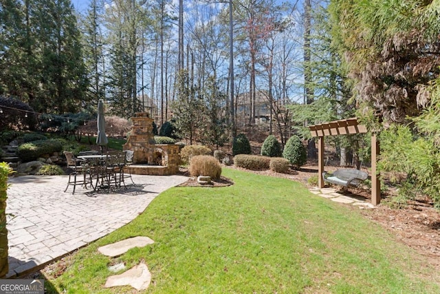 view of yard with an outdoor stone fireplace and a patio