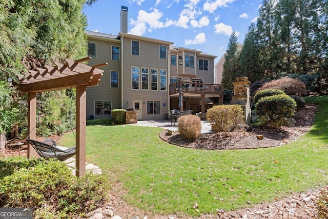 back of house featuring a patio, a pergola, a chimney, a deck, and a lawn