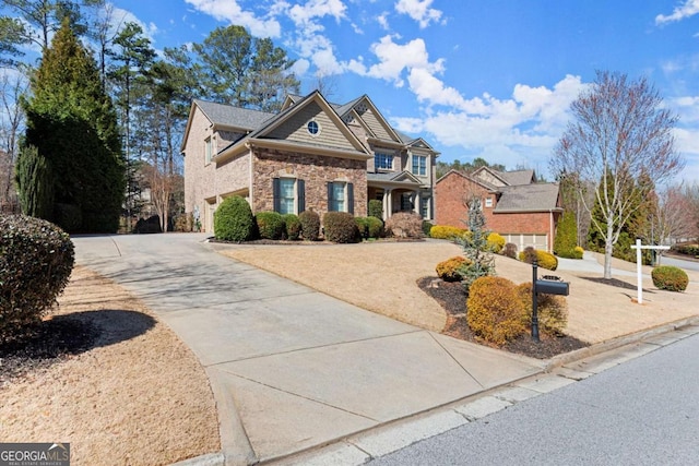 craftsman-style house featuring stone siding and concrete driveway