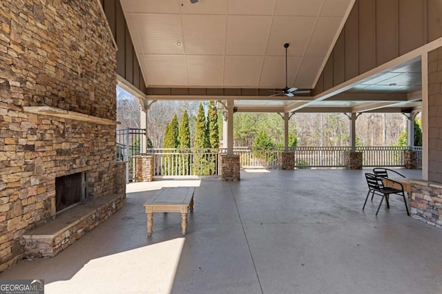 view of patio with an outdoor stone fireplace and a ceiling fan