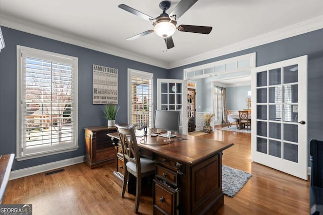 home office featuring visible vents, ornamental molding, a ceiling fan, wood finished floors, and baseboards