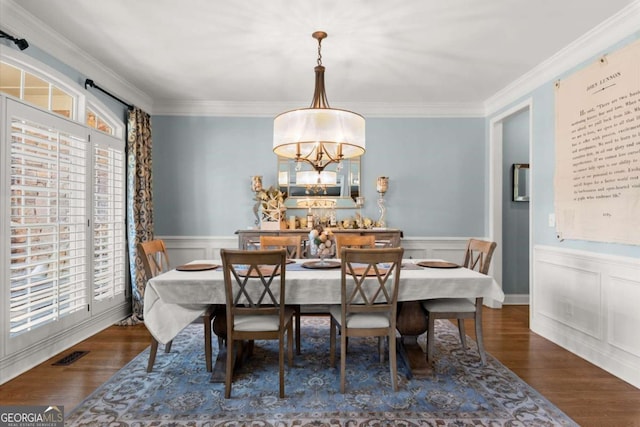 dining room with visible vents, a wainscoted wall, wood finished floors, and ornamental molding