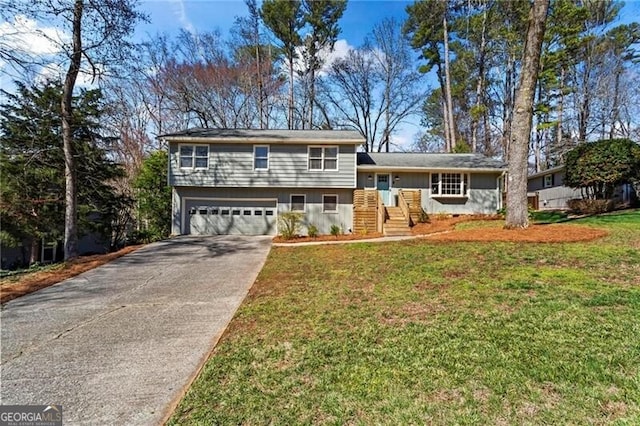 split level home with a front lawn, an attached garage, and concrete driveway