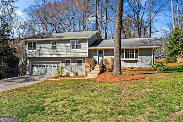 split level home featuring a front lawn, an attached garage, and concrete driveway