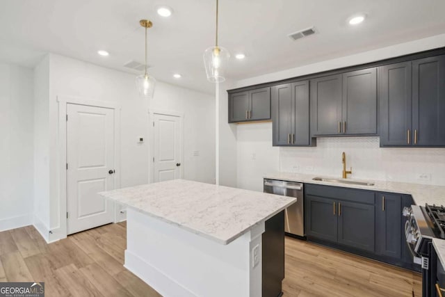 kitchen featuring visible vents, appliances with stainless steel finishes, light wood-style floors, and a sink