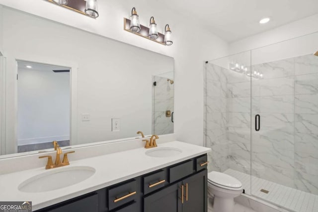 bathroom featuring double vanity, toilet, a marble finish shower, and a sink