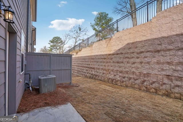 view of yard featuring central AC unit and fence