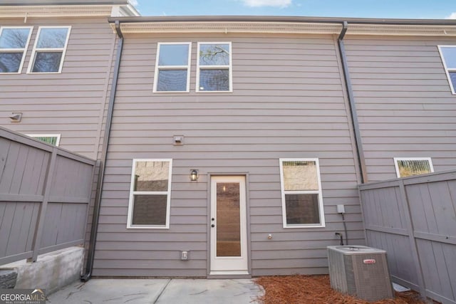 rear view of house with a patio area, central air condition unit, and fence