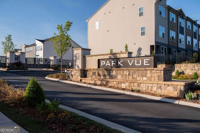 community / neighborhood sign with fence and a residential view