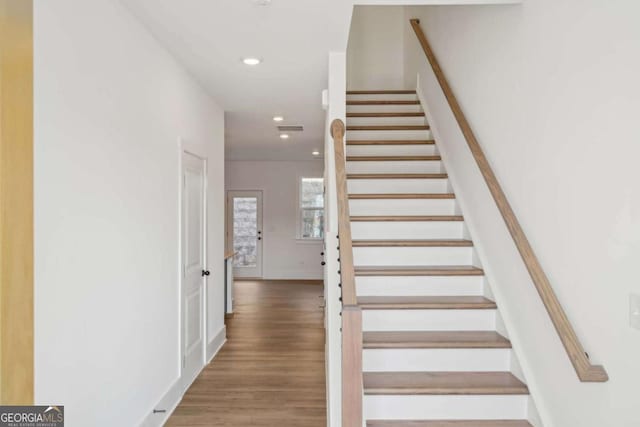 stairway with recessed lighting, visible vents, baseboards, and wood finished floors