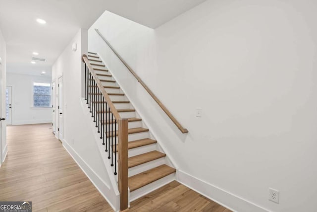 staircase featuring recessed lighting, baseboards, and wood finished floors