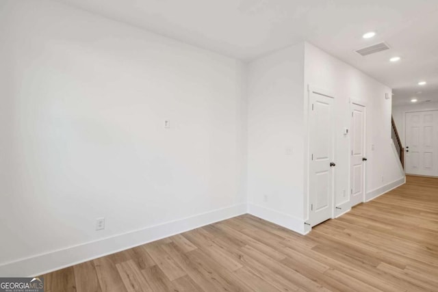 empty room with recessed lighting, visible vents, light wood-style flooring, and baseboards