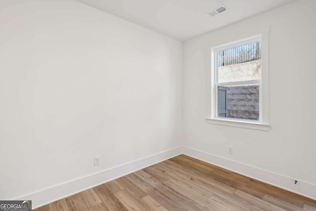 empty room with visible vents, wood finished floors, and baseboards