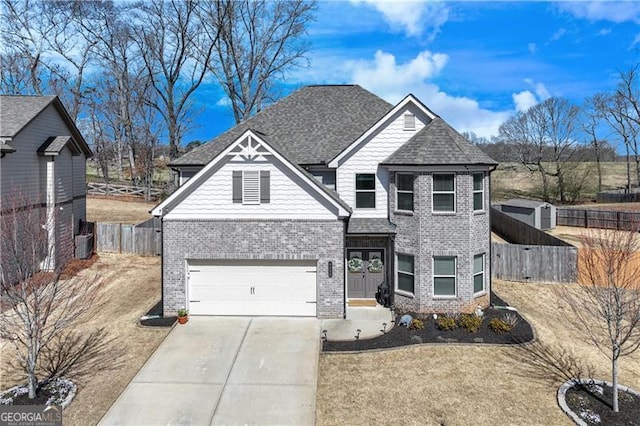 craftsman-style home with fence, a shingled roof, concrete driveway, a garage, and brick siding