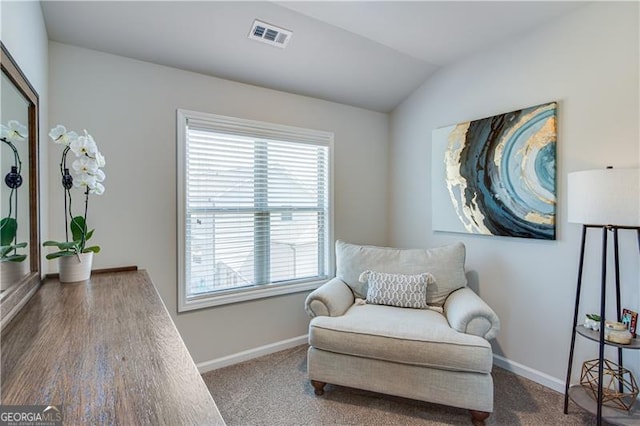 living area with visible vents, baseboards, carpet, and vaulted ceiling