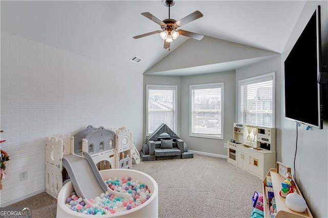 recreation room featuring visible vents, carpet flooring, a ceiling fan, and lofted ceiling