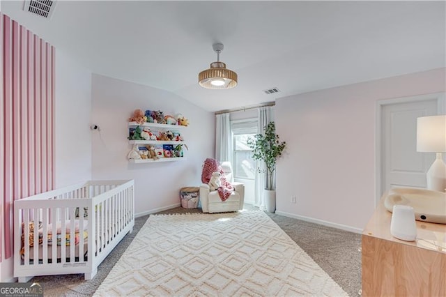 carpeted bedroom featuring lofted ceiling, baseboards, visible vents, and a sink