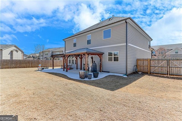 back of property featuring a gazebo, a patio area, a residential view, and a fenced backyard