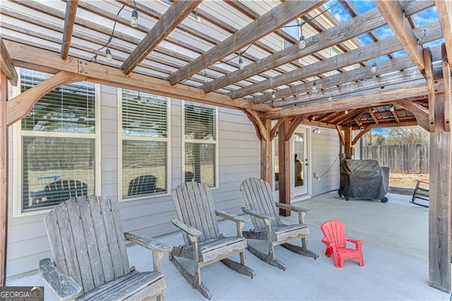 view of patio featuring grilling area, a pergola, and fence