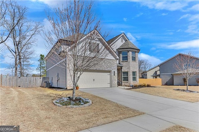 view of front of property featuring driveway, fence, cooling unit, a garage, and brick siding