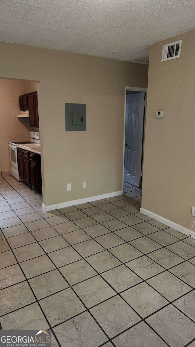 interior space featuring electric panel, baseboards, visible vents, and a textured ceiling