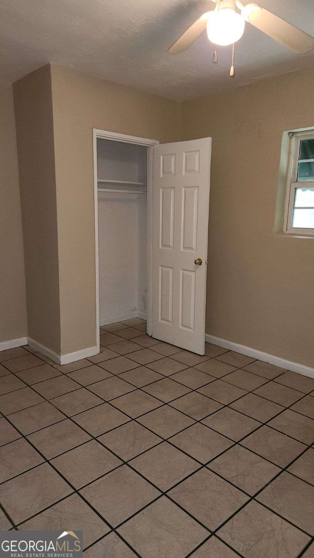 unfurnished bedroom featuring baseboards, a closet, and ceiling fan