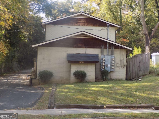 view of side of home with brick siding and a yard