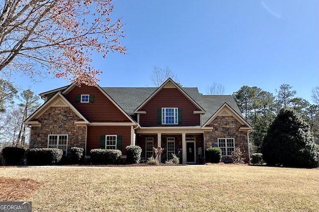 craftsman-style house featuring a front lawn and stone siding