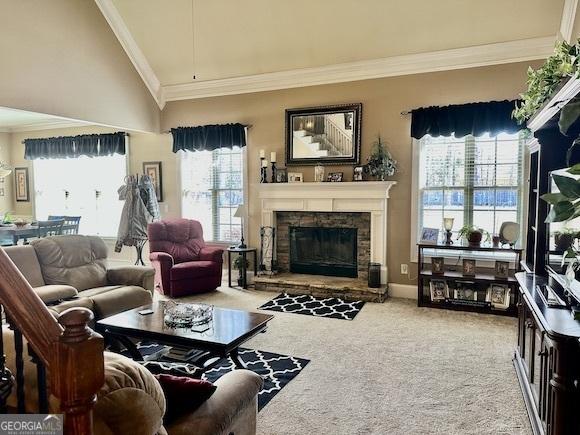 carpeted living room with a stone fireplace and crown molding