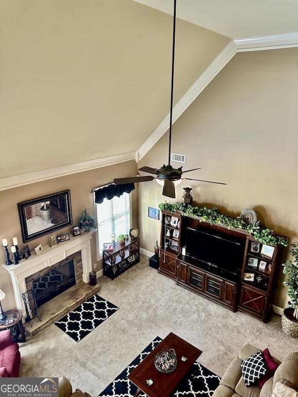 carpeted living area with visible vents, baseboards, ornamental molding, a premium fireplace, and high vaulted ceiling