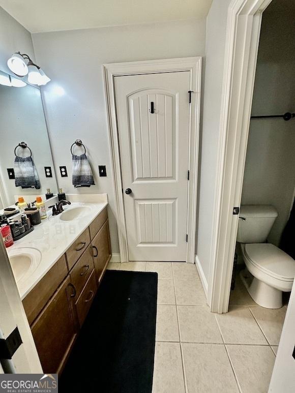 bathroom featuring tile patterned floors, double vanity, and a sink