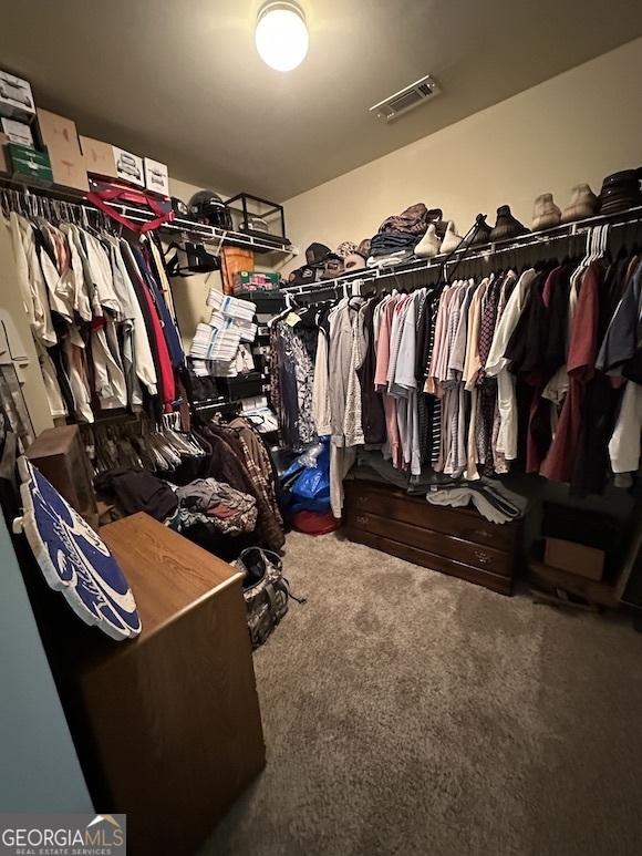 walk in closet featuring visible vents and carpet flooring