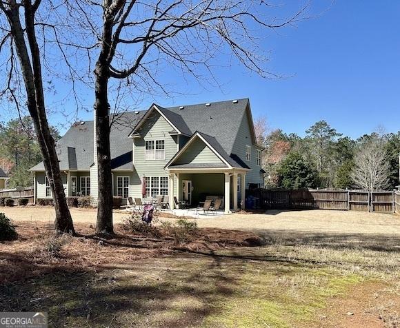 rear view of property with a patio area and fence