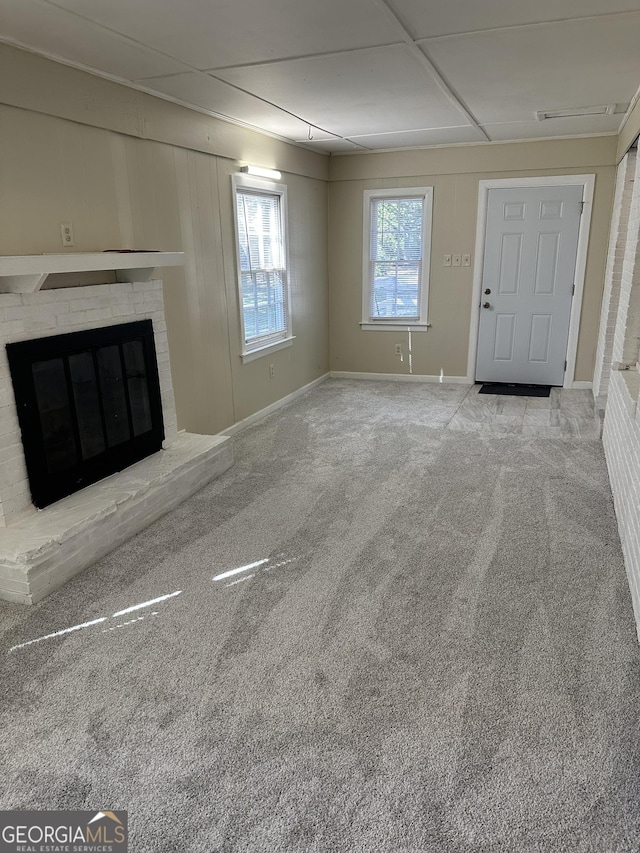 unfurnished living room featuring carpet flooring and a fireplace