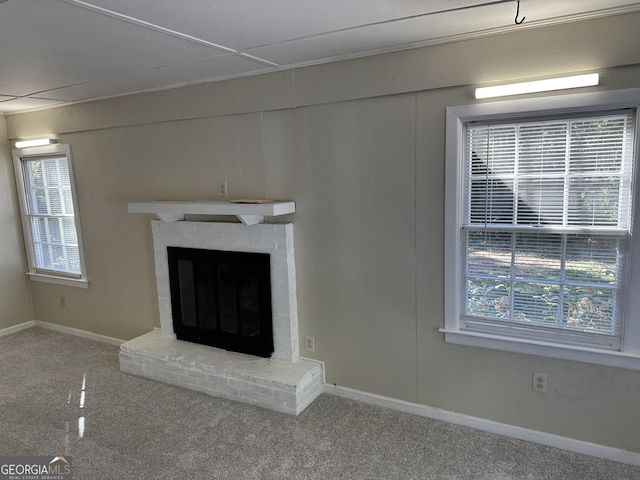 unfurnished living room featuring carpet flooring, baseboards, and a fireplace