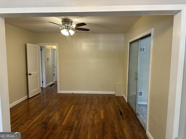 spare room with visible vents, baseboards, and dark wood-style floors