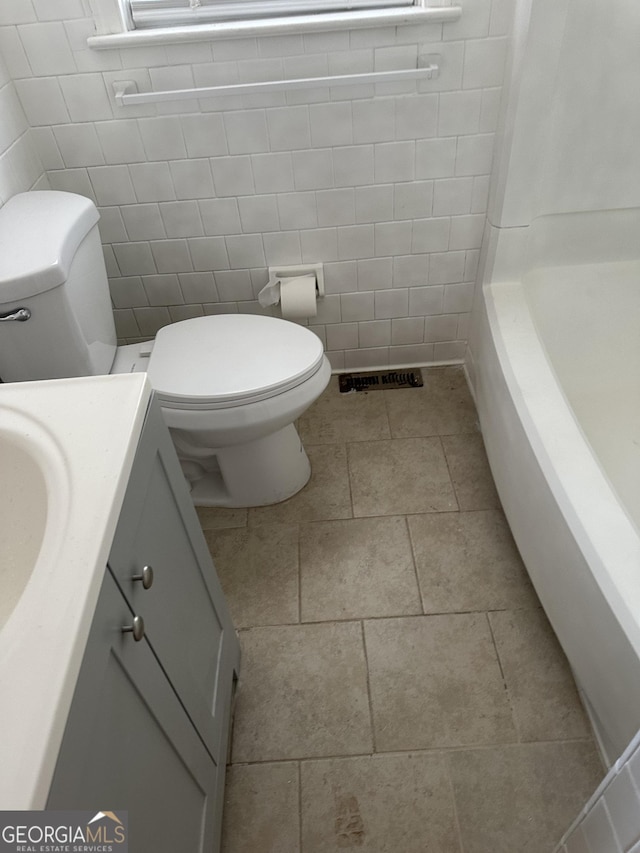 bathroom with visible vents, toilet, vanity, and walk in shower