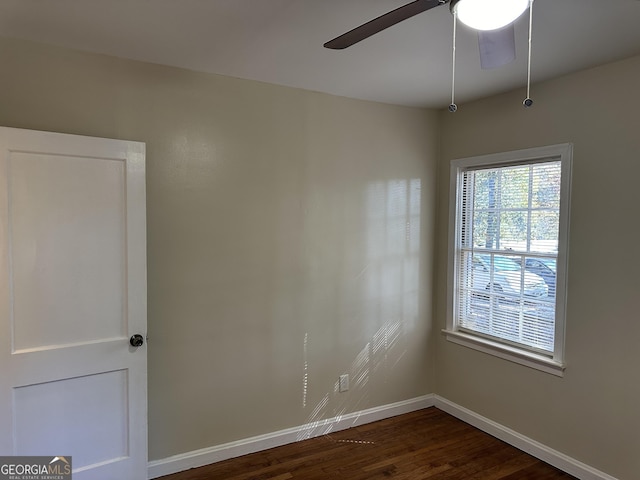 spare room with dark wood-style floors, ceiling fan, and baseboards